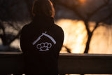 Man looking at sunset over river while standing on a bridge.