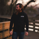 Man walking on bridge with black savage gentleman hoody.