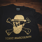 Nahaufnahme eines Toxic Masculinity T-Shirts in Schwarz und Gold.