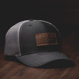 Savage Gentleman Trucker Hat mit Lederaufnäher aus grauem Mesh und Schwarz.