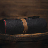 Savage Gentleman wool blanket with red stitching and leather strap.